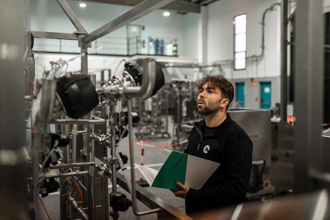 En tekniker inspekterar teknisk utrustning och maskiner i en fabrik.