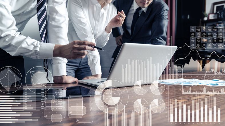 Affärsfolk som analyserar data på en bärbar dator för att minska kreditrisken.
